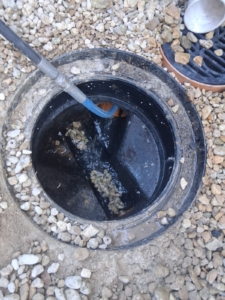 Drain rod clearing a blocked manhole chamber